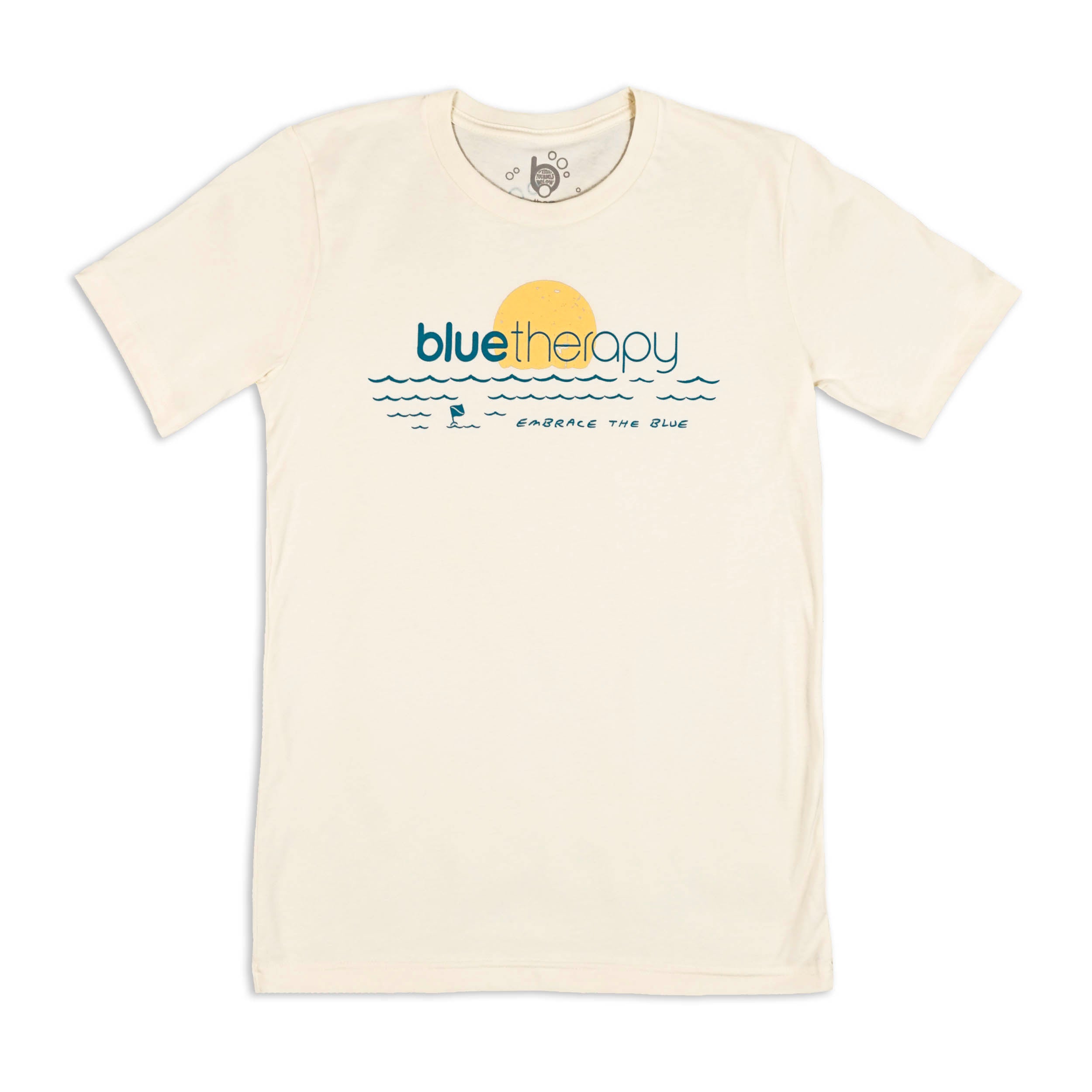 Front of beige BlueTherapy Embrace t-shirt, retro yellow/blue minimalist graphic design of sunset and waves design with small diver down flag and handwritten text 'Embrace the Blue' in the waves