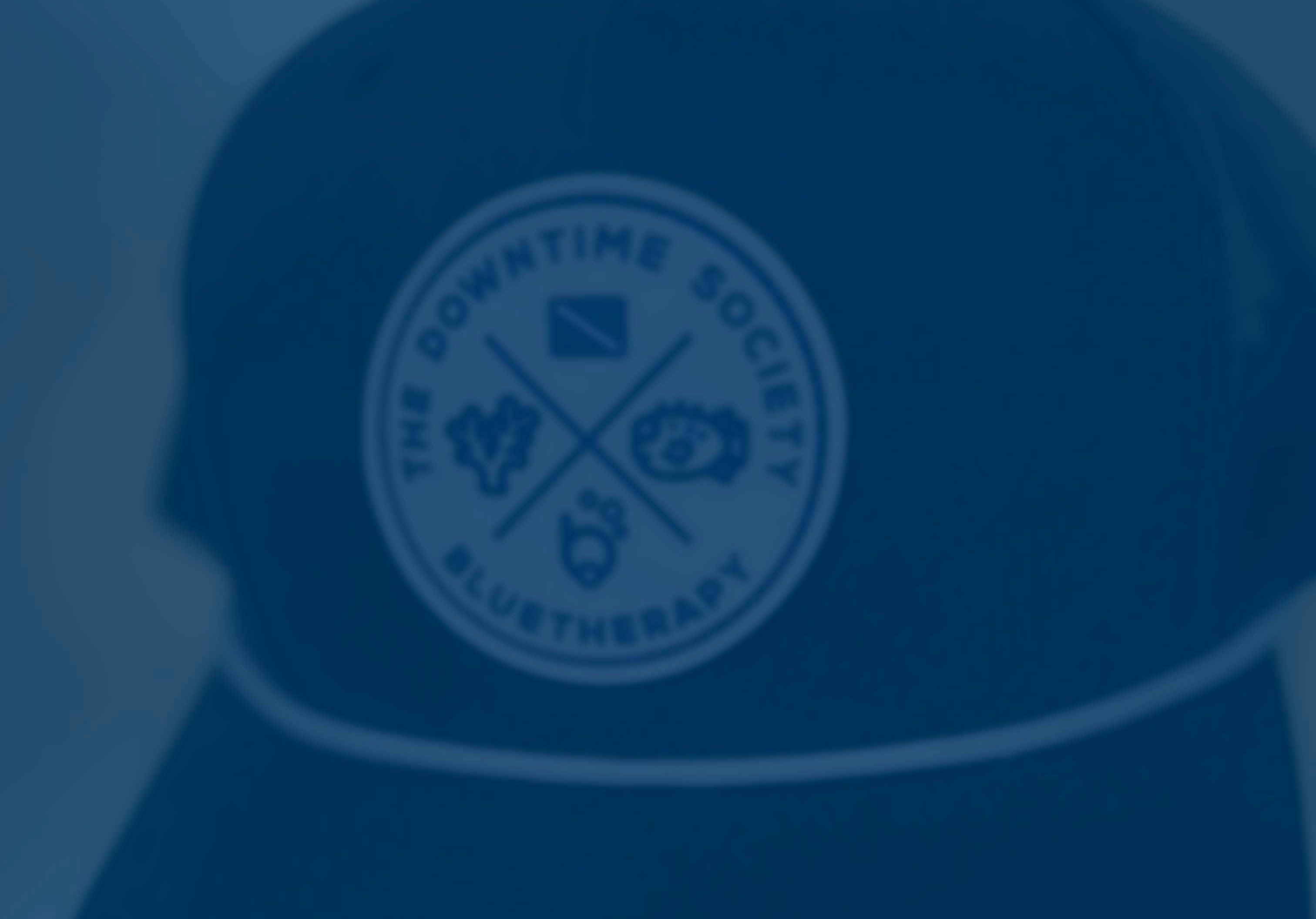 Blue tinted blurred image of BlueTherapy Downtime Society trucker hat with a logo